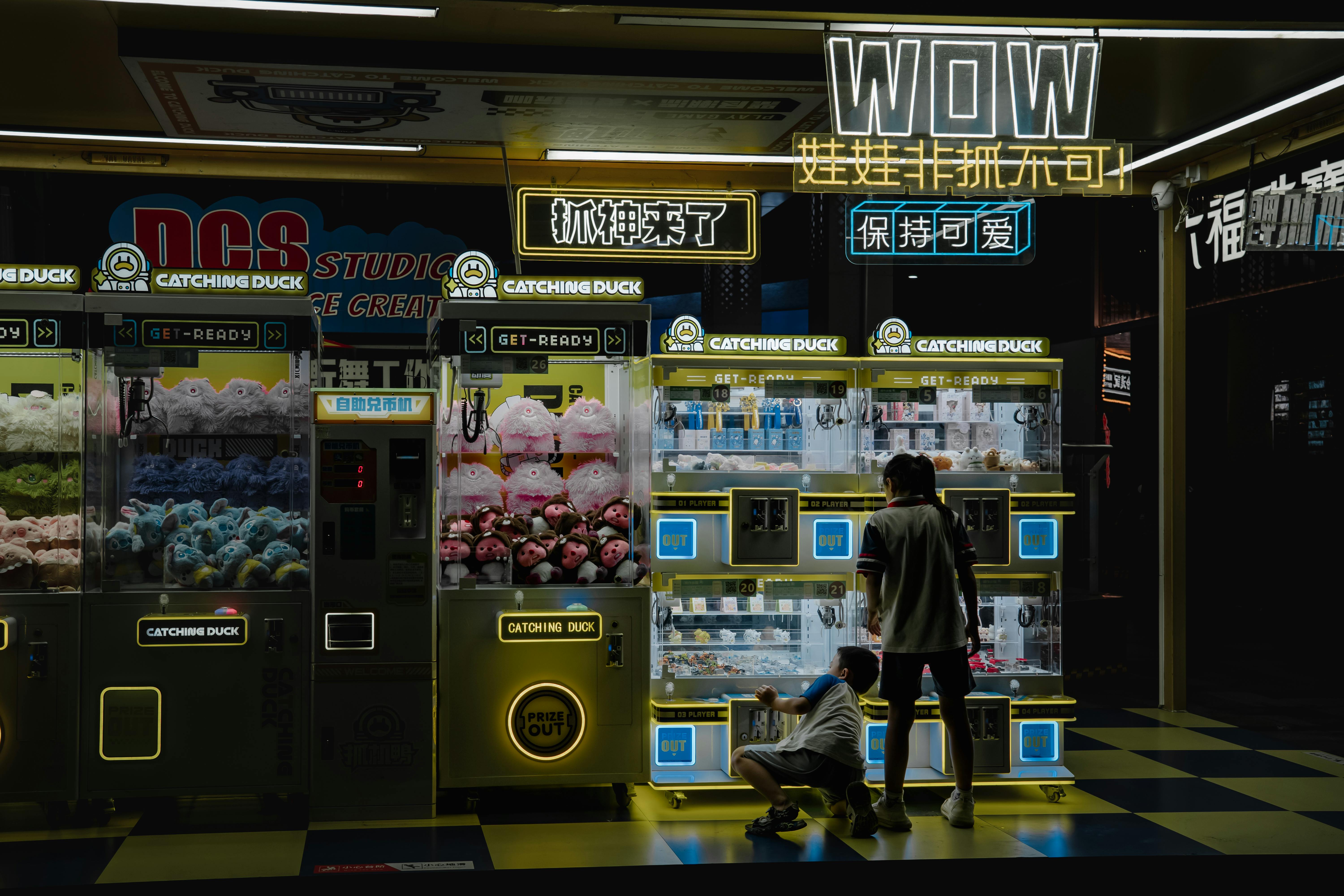 Kids at neon claw machine arcade